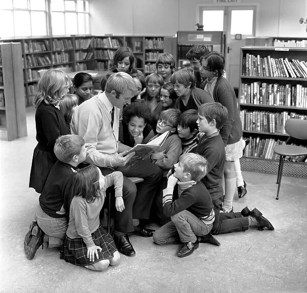 Blackburn Rovers footballer Ken Knighton pictured reading stories to a group of children