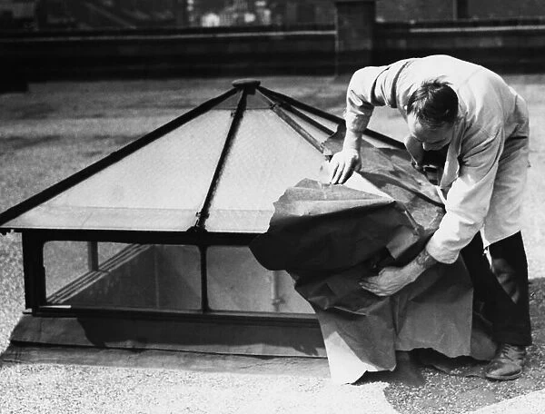 Blackout preparations hiding skylights on rooftop with paper. 13th July 1939