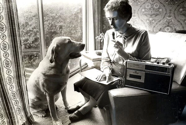 Blind Cardiff City Councillor Joan Ward, recording her notes while her guide dog Jenny