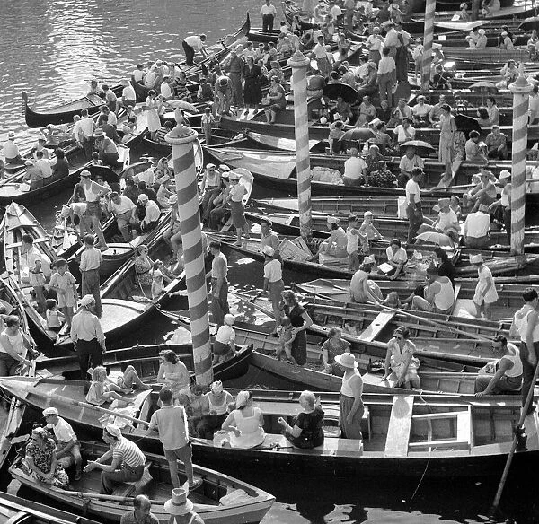 Boats and gondolas tied up as the procession of gondolas pass along the Grand Canal
