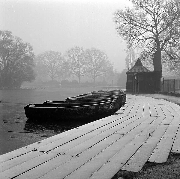 boats lined up at a lake in an english park rural scenic water foggy haze mist