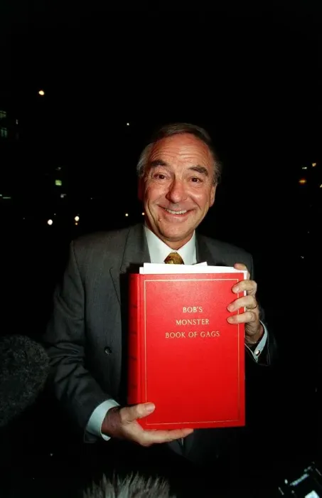 Framed Print : Bob Monkhouse Comedian and TV Presenter holding the book of gags that was stolen from his Framed Print : Bob Monkhouse Comedian and TV Presenter holding the book of gags that was stolen from his