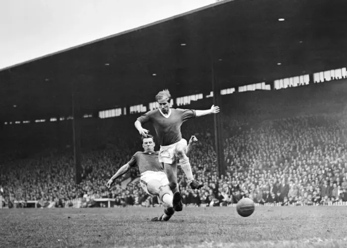 Framed Print : Bobby Charlton leaps to elude a defender during the match between Manchester United