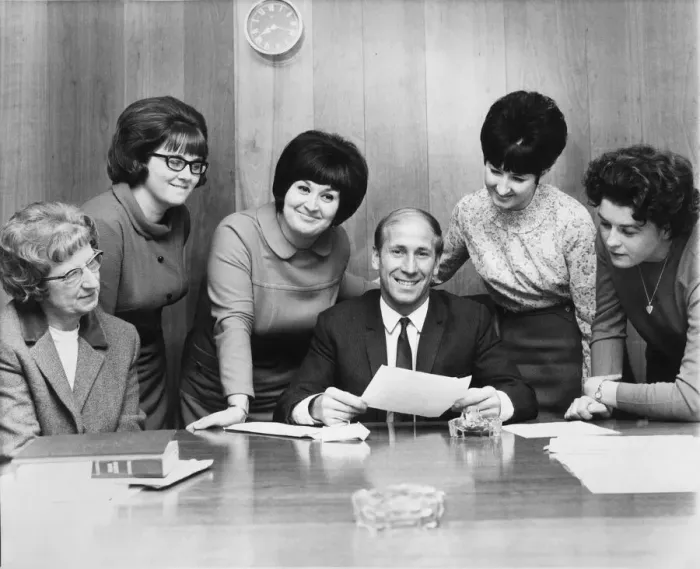 Framed Print : Bobby Charlton pictured amongst female staff at The Manchester United Fan Club