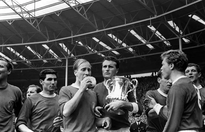 Framed Print : Bobby Charlton with sponge and Noel Cantwell holding the trophy after beating Leicester