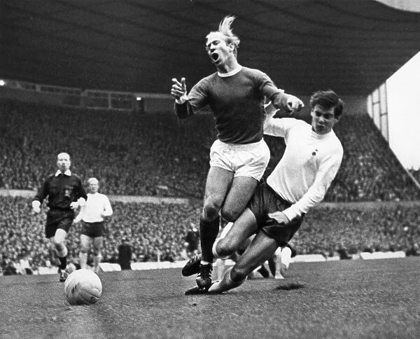 Bobby Charlton is tacked by Cyril Knowles during the Manchester United verses Tottenham