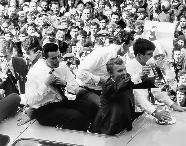 Bobby Moore holds up the FA Cup on the coach as the team return with Johnny Byrne