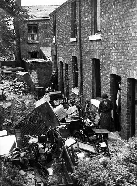 Bomb damage in Liverpool. Residents in these cottages salvaging their belongings after an