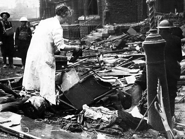 Bomb damage in Liverpool during the Second World War. A woman searches the wreckage of