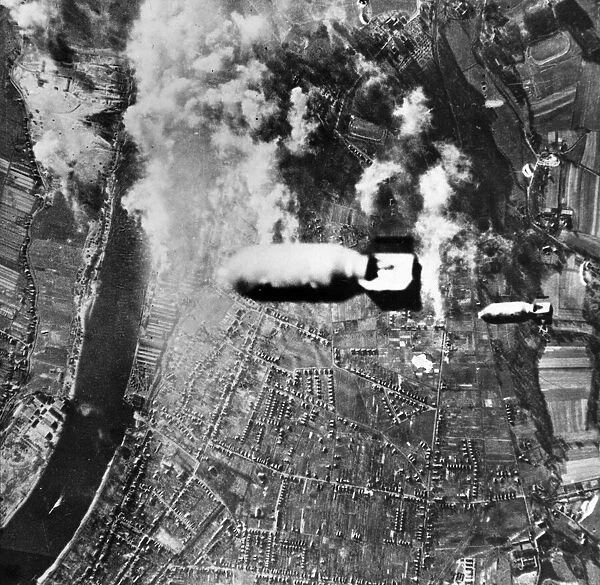 Two bombs drop from a US heavy bomber towards U-boat yards in the German district of