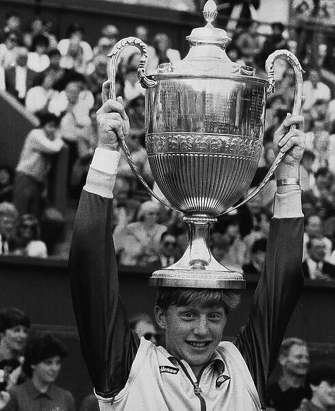 Boris Becker tennis holding the Wimbledon Trophy on top of his head after becoming
