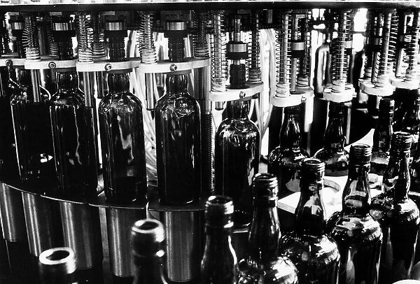 Bottle of Whisky on the conyevor belt at a a bottling plant 1971