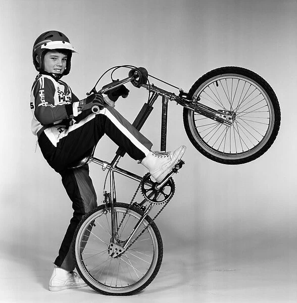 A boy with a BMX bike and wearing a BMX outfit. 25th November 1983