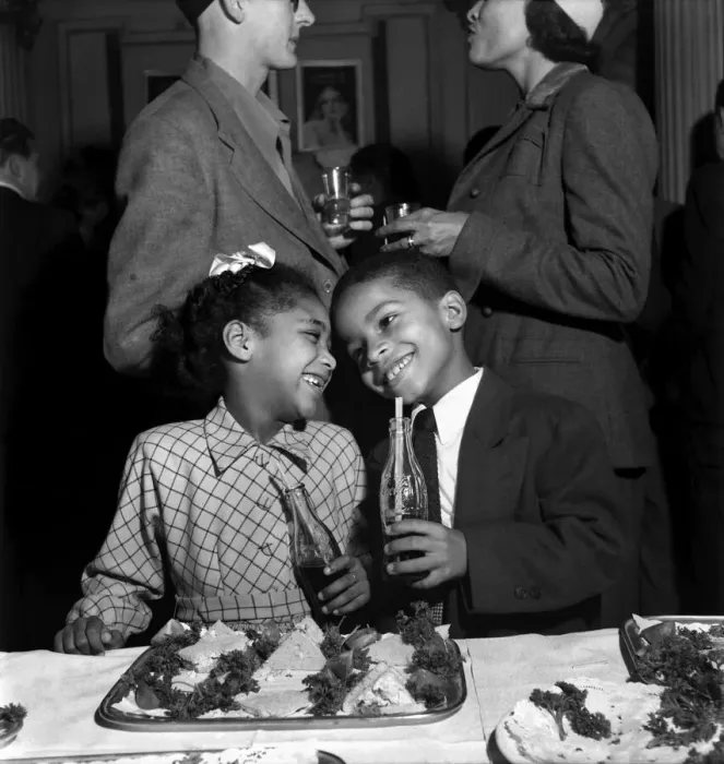 Framed Print : Boy and Girl aged 7 enjoy a drink and food at a reception for the cast of Porgy and Bess