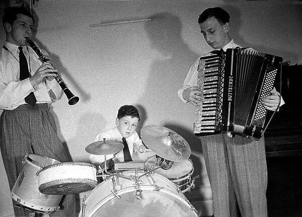 Boy musician Victor Feldman on his drum kit with band members playing the clarinet