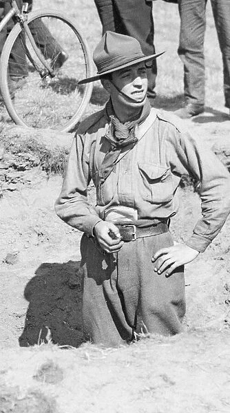A Boy Scout stands in one of the craters made as a result of one of the three air raids
