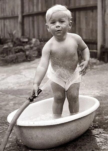 Boy washing in a bath tub. Circa 1950