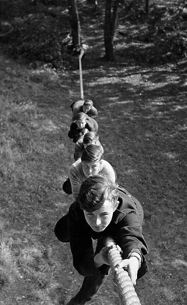 Boys climbing up a rope at the Outward Bound Sea School at Aberdovey Wales