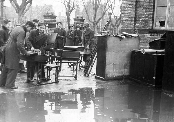 Boys engage in salvage work from a burnt out school in Cardiff after an attack by Nazi