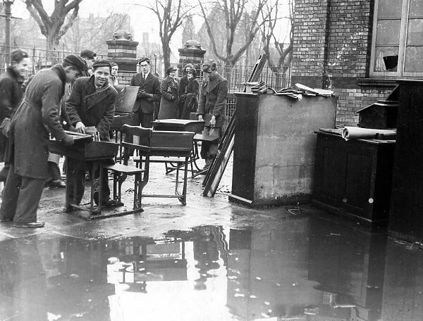 Boys engaged in salvage work from a burnt out school in Cardiff, Wales