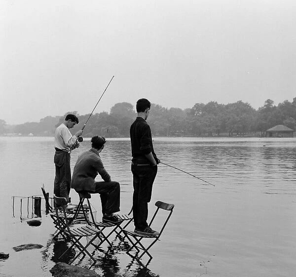 Boys fishing on the Serpentine in Londons Hyde Park. 8th August 1957