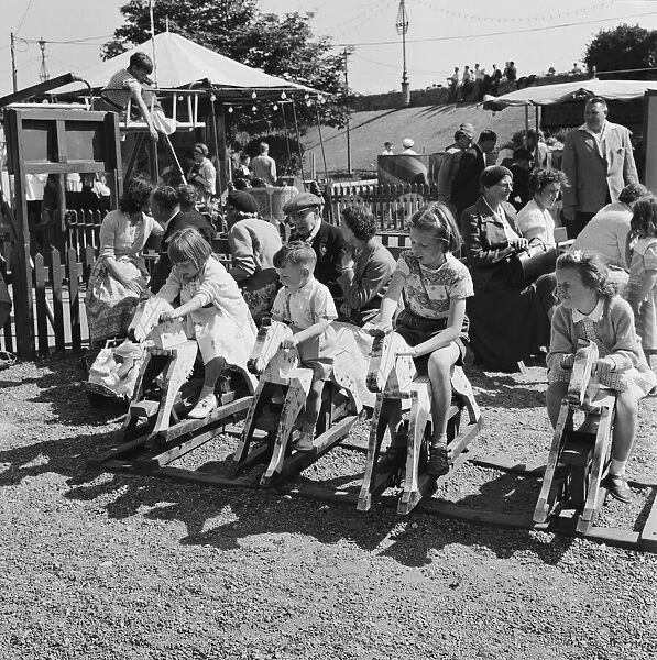 Boys and girls playing on the rocking horses at a childrens playground in Southend