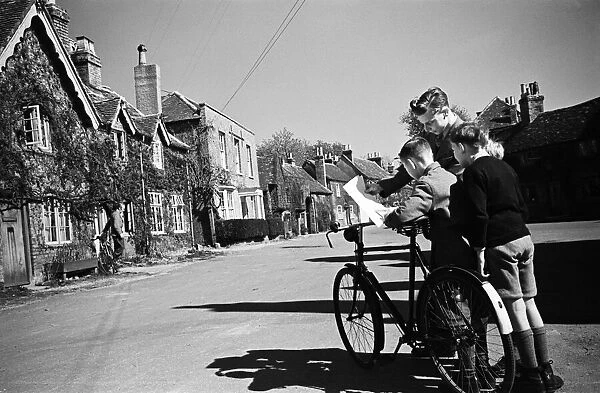 Three boys looking at directions on Village Road, Denham, Buckinghamshire. Circa 1945