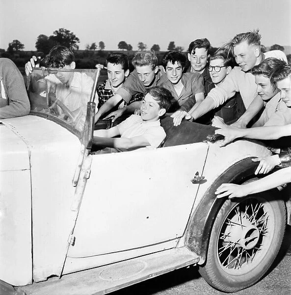 Boys Motor Club. Children sitting in the back of a car being pushed along