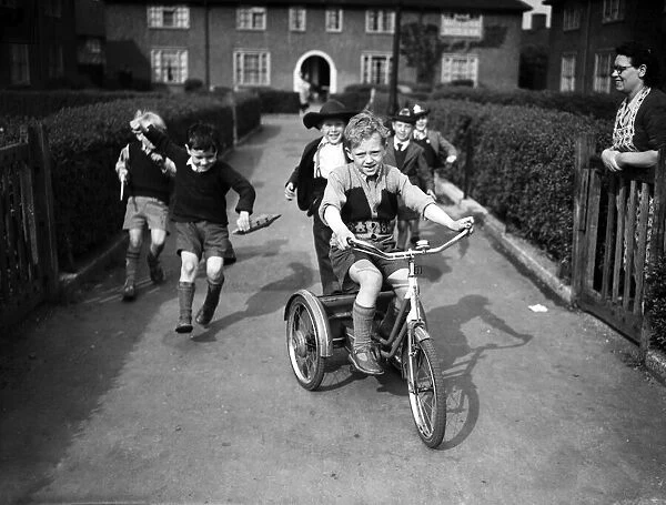 Boys playing on a council estate as one of their mothers looks on, London. 1955