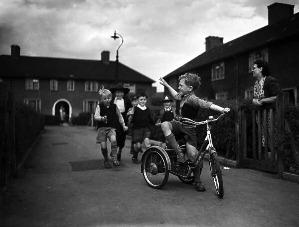 Boys playing on a council estate as one of their mothers looks on, London, 1955