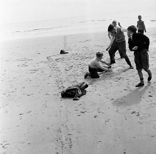 Boys playing football on a beach in Sunderland, Tyne and Wear (formally County Durham)