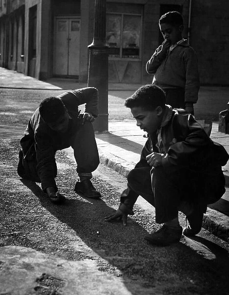 Boys playing marbles in Butetown, Cardiff. 22nd March 1957