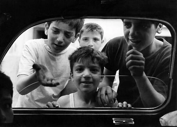 Boys from the slum areas of Naples in southern Italy beg for money through car windows