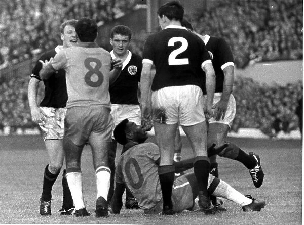 Brazilian football star Pele on a heap on the ground after clashing with Scotland