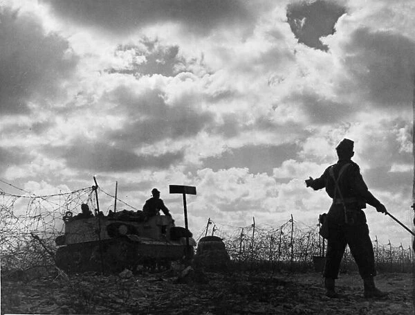 A Bren Carrier being guided through barbed wire during the first stages of the offensive