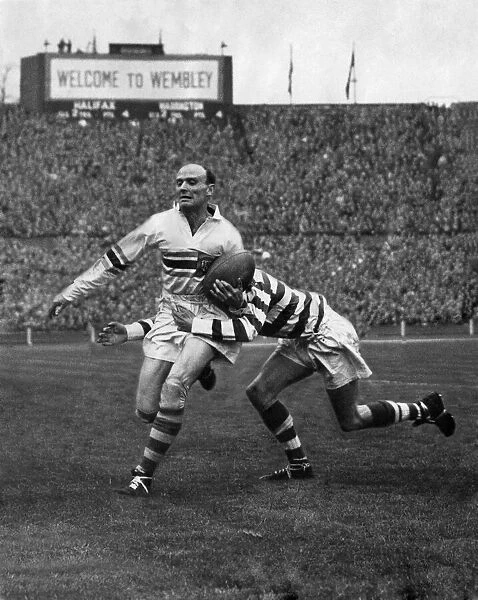 Brian Bevan of Warrington is well tackled by D. R. Bevan of Halifax. April 1954 P005845