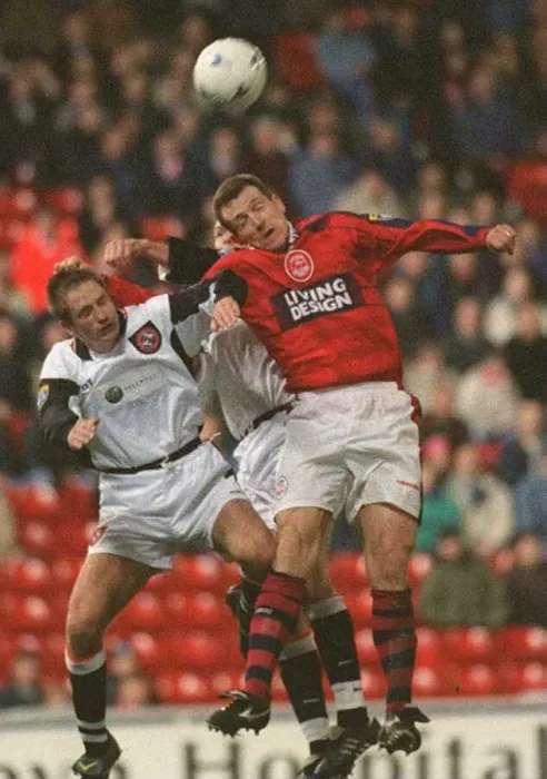  : Brian Irvine Aberdeen football player challenges Dundee United players for the ball