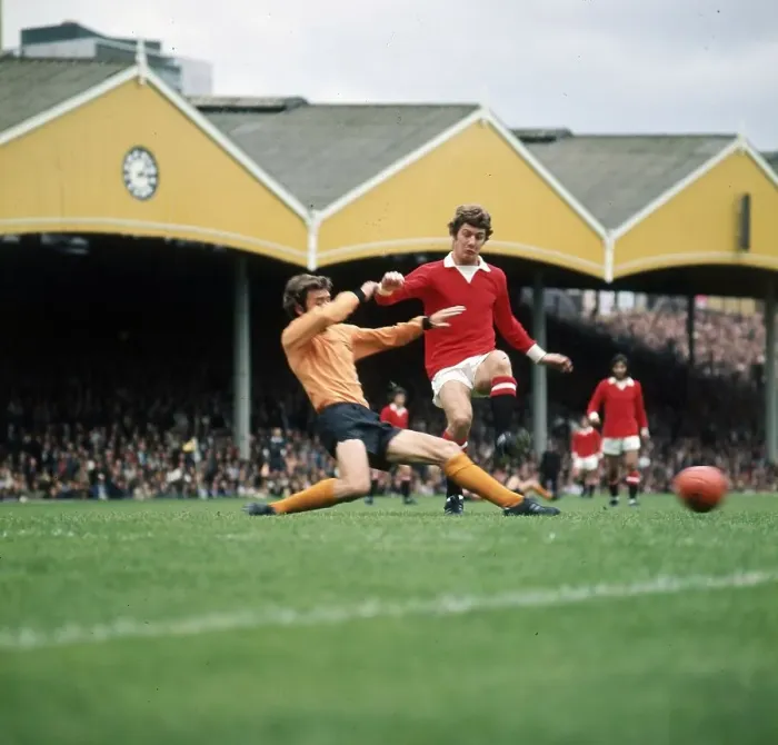 Framed Print : Brian Kidd of Manchester United takes on v J McAlle of Wolves