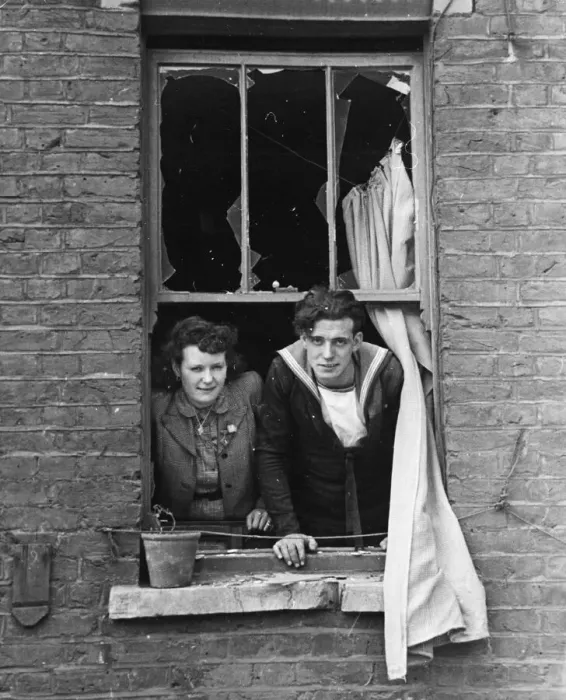 Framed Print : The bride and Royal Navy groom look out of their window, onto where a bomb recently fell Framed Print : The bride and Royal Navy groom look out of their window, onto where a bomb recently fell