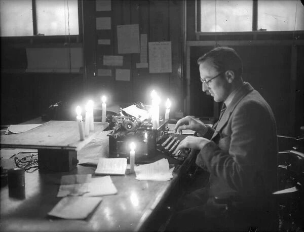 Bristol a newspaper reporter works by candlelight in January 1941 after bombs cut off