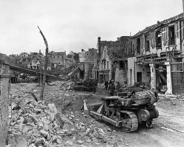 British advance in Normandy. Bulldozers clearing debris after entering Faubourg de