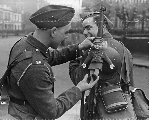 British Army, a fellow soldier adjust the lady doll to his comrades gun