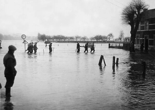 British Army sappers of the Royal Engineers wade through the floods on the banks of