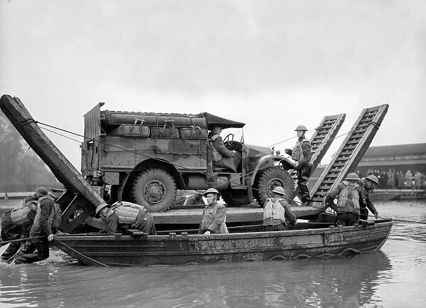 British army soldiers with an all terrain vehicle crossing over water on a pontoon during