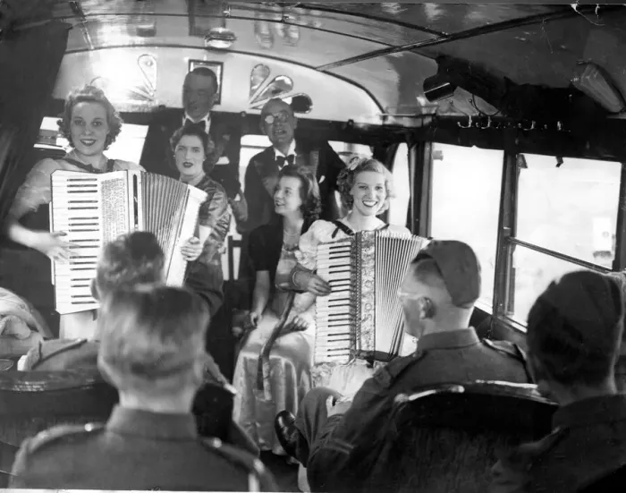 Framed Print : British army soldiers enjoy a performance from girls playing accordions at their mobile