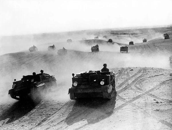British army vehicles carrying Bren guns move across the sands of the North African