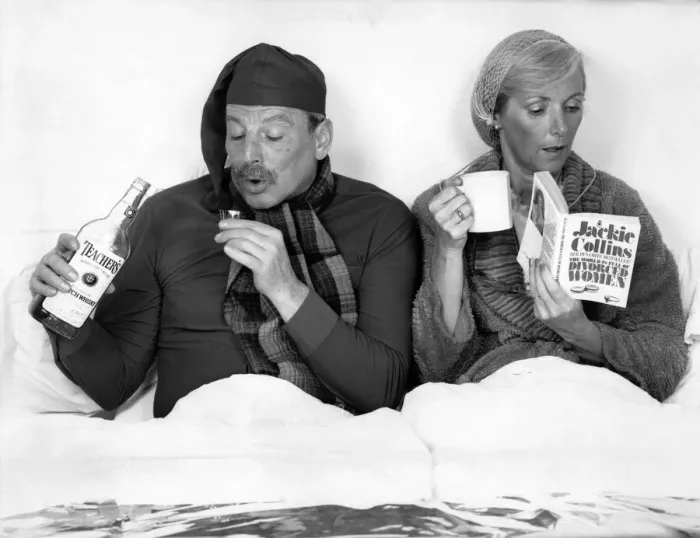 Framed Print : The British at bed time. Husband and wife in bed. He drinks whisky while she reads her