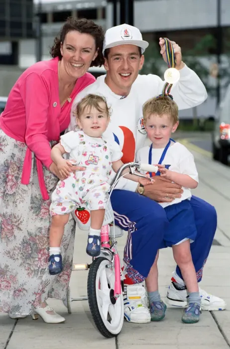 Framed Print : British cyclist Chris Boardman poses with his family on arrival at Manchester airport as Framed Print : British cyclist Chris Boardman poses with his family on arrival at Manchester airport as