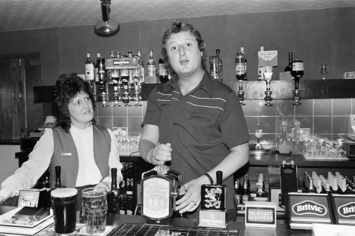 Framed Print : British dart player Eric Bristow pictured at the pub, serving drinks behind the bar