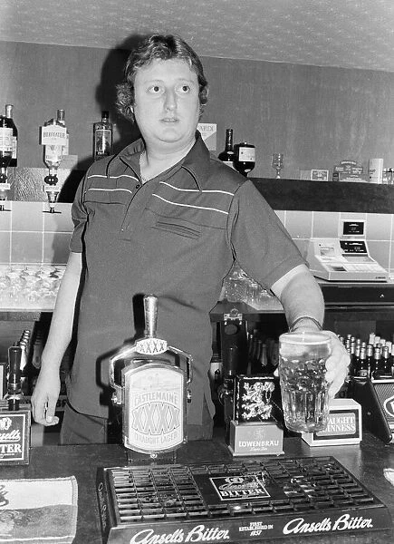 British dart player Eric Bristow pictured at the pub, serving drinks behind the bar
